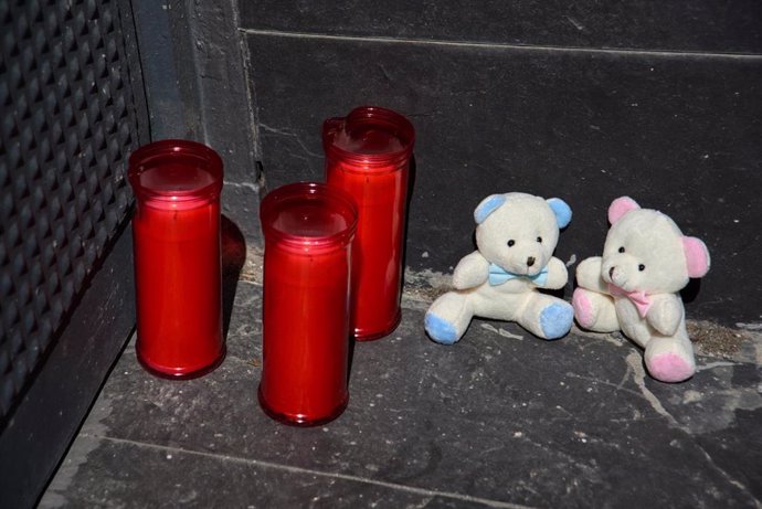 Tres velas y dos osos de peluche en la puerta del garaje de la vivienda donde un hombre ha matado presuntamente a su mujer y sus dos hijos menores, 10 de abril de 2024, en El Prat de Llobregat, Barcelona, Catalunya (España). Los Mossos d'Esquadra investig