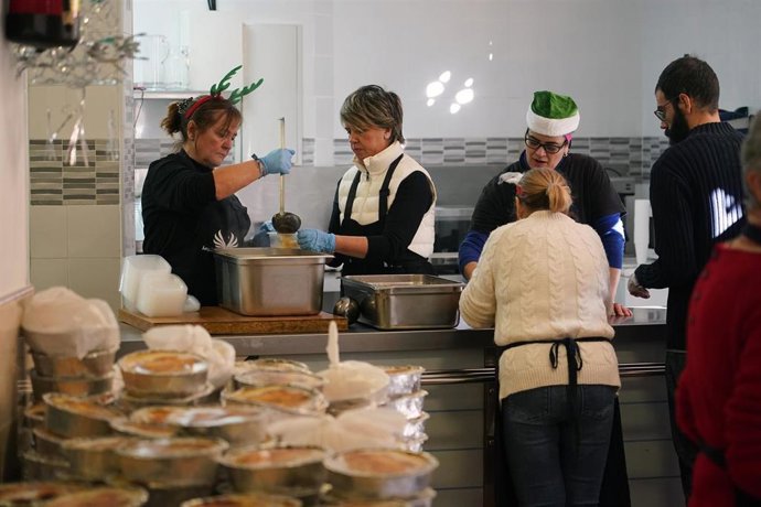 Archivo - Varios voluntarios de la asociación malagueña Los Ángeles de la Noche, reparten menús navideños a personas sin recursos en la mañana previa a Nochebuena a 23 de diciembre de 2023 en Málaga (Andalucía, España)