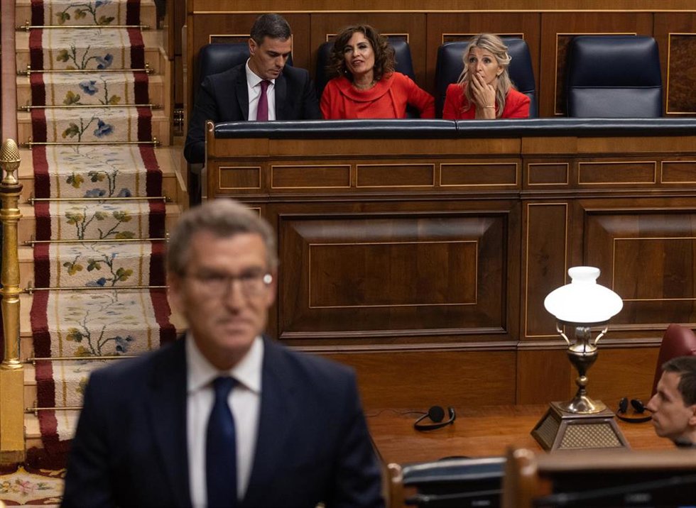 (I-D) El presidente del Gobierno, Pedro Sánchez; la vicepresidenta primera y ministra de Hacienda, María Jesús Montero y la vicepresidenta segunda y ministra de Trabajo, Yolanda Díaz, mientras llega a intervenir el líder del PP, Alberto Núñez Feijóo, du