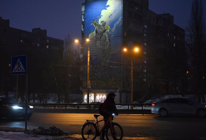 Archivo - Un hombre cerca de un mural en la capital de Ucrania, Kiev, en honor a los encargados de los sistemas de defensa aérea y los trabajadores del sistema energético (archivo)
