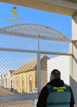 Un agente junto a la entrada al cementerio parroquial de la pedanía murciana de Lobosillo
