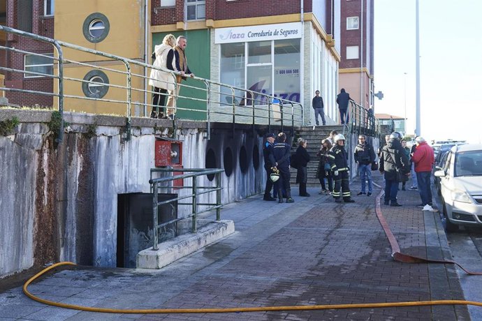 Bomberos y vecinos en las inmediaciones del incendio de un garaje comunitario en la calle José María Cossío, a 11 de abril de 2024, en Los Acebos, Santander, Cantabria (España). 