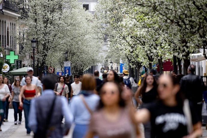 Varias personas pasean junto a árboles en flor durante el primer día de primavera, a 20 de marzo de 2024, en Madrid (España).