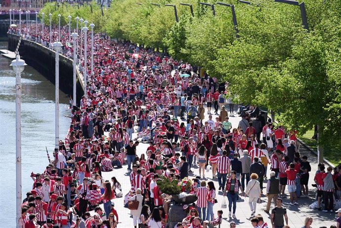 Imagen de los aficionados del Athletic Club esperando en los márgenes de la Ría la lllegada de la gabarra para celebrar la Copa del Rey