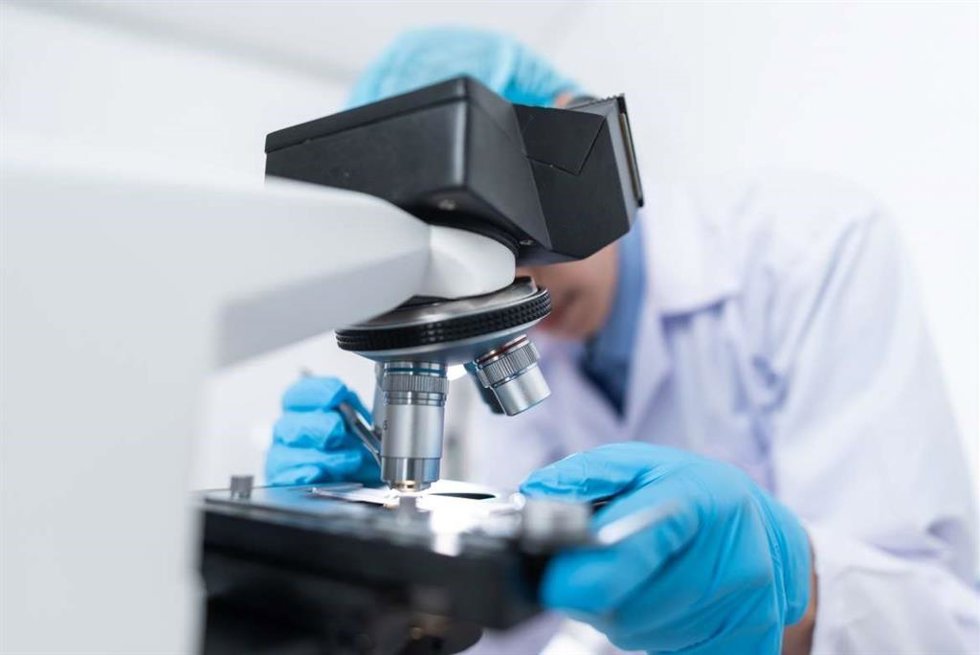 Archivo - Un científico utiliza un microscopio
