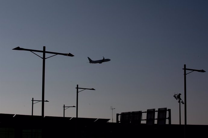 Archivo - Un avión sobrevuela el Aeropuerto de Barcelona-El Prat