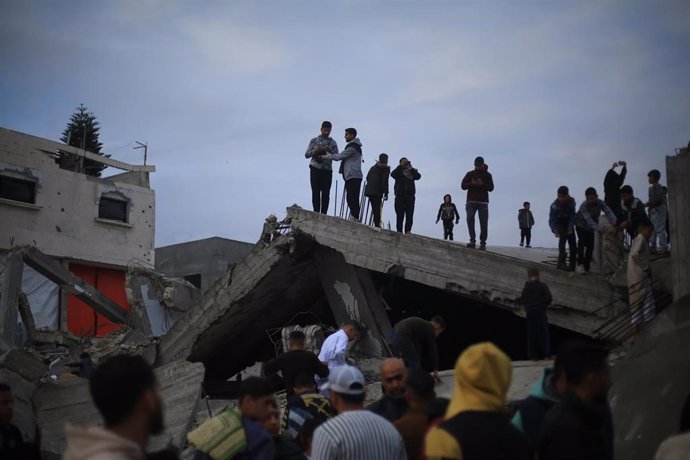 Un grupo de palestinos sobre las ruinas de una mezquita destruida en Rafá, Franja de Gaza