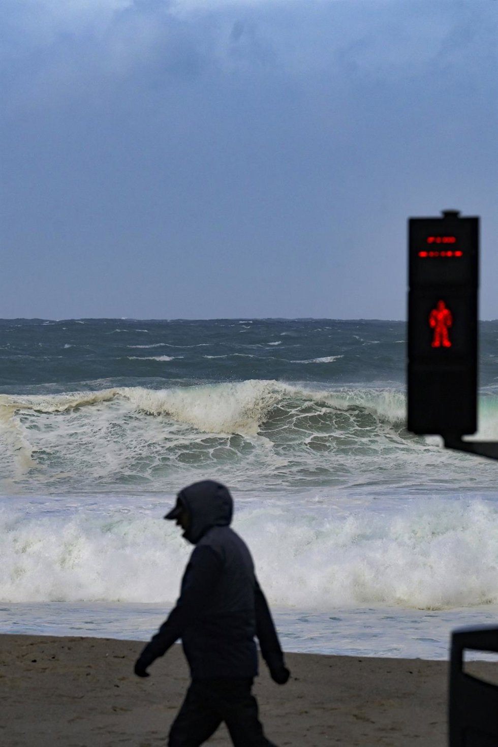 Archivo - Una persona camina delante de las olas durante el frente meteorológico, a 23 de febrero de 2024, en A Coruña, Galicia (España). La Agencia Estatal de Meteorología (Aemet) decretó un aviso naranja por temporal costero en el litoral gallego que 