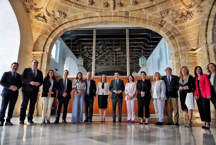 El presidente de la Junta de Andalucía, Juanma Moreno (c.), junto a alcaldes y otros cargos del PP en la provincia de Málaga que reivindican el tren del litoral de la Costa del Sol, este jueves en el Parlamento