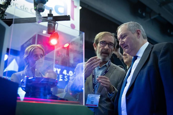 El presidente de Fira de Barcelona, Pau Relat (2i), y el ministro de Industria y Turismo, Jordi Hereu (1d), conversan frente a un estand a su llegada a la Fira de Barcelona Gran Via