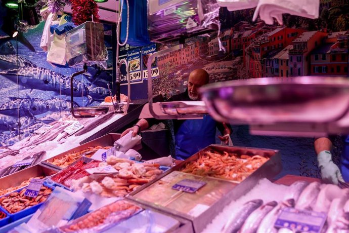Archivo - Un pescadero realiza sus últimas ventas de pescado y  marisco en la tienda de comestibles Los Mares Alimentación, en el barrio de Prosperidad, a 24 de diciembre de 2022, en Madrid (España).