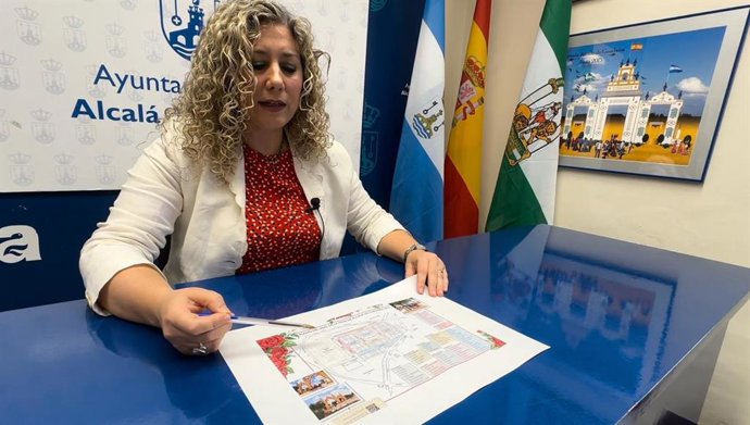 La delegada Fiestas Mayores del Ayuntamiento de Alcalá de Guadaíra, Rocío Bastida, muestra el mapa de los aparcamientos establecidos para la Feria.