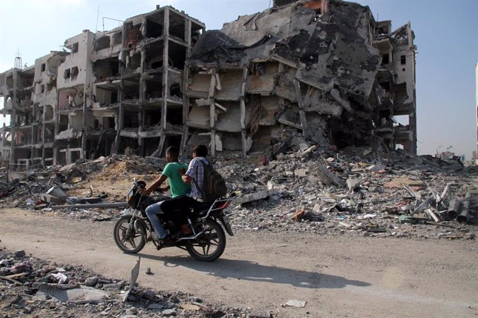 Archivo - Oct. 28, 2013 - Gaza City, Gaza Strip, Palestinian Territory - Palestinian men ride a Motorcycle past destroyed and badly damaged residential buildings as they return to Beit Lahiya town, which witnesses said was heavily hit by Israeli shelling 