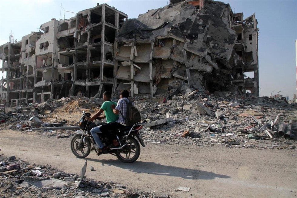 Archivo - Oct. 28, 2013 - Gaza City, Gaza Strip, Palestinian Territory - Palestinian men ride a Motorcycle past destroyed and badly damaged residential buildings as they return to Beit Lahiya town, which witnesses said was heavily hit by Israeli shellin