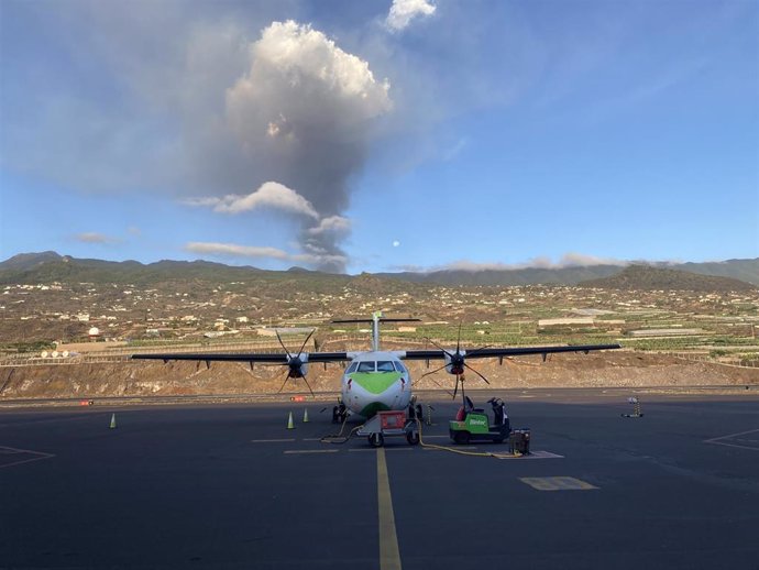 Archivo - Un avión en la pista del aeropuerto de La Palma, con el volcán en erupción al fondo