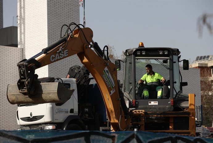 Archivo - Un hombre con una máquina excavadora trabaja en una obra.