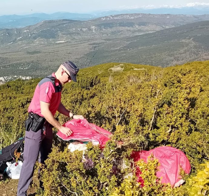 Un agente de la Policía Foral sujeta el parapente de la persona fallecida.
