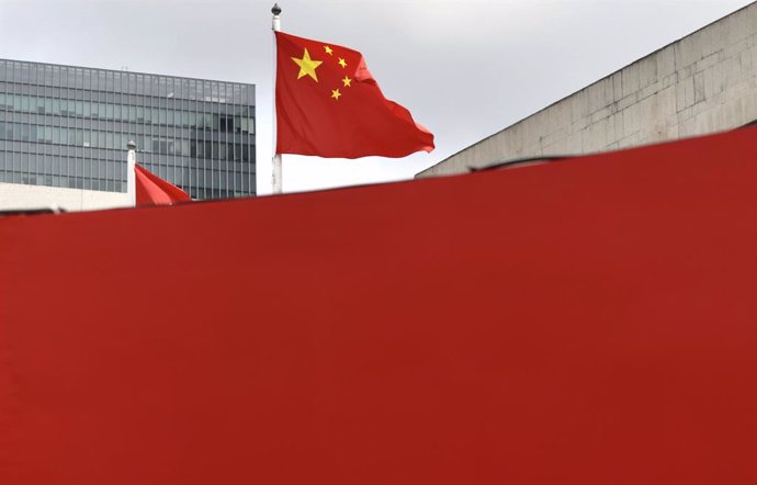 March 30, 2024, Hong Kong, CHINA: Chinese Red Flag is flying on the pole behind the red painted wall in the financial centre in Hong Kong.Mar-30,2024Hong Kong.ZUMA/Liau Chung-ren