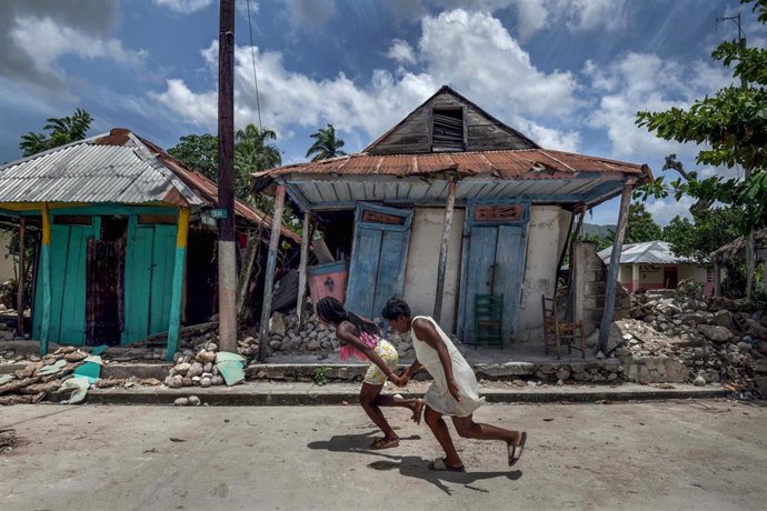 Archivo - Niñas corren frente a casas dañadas por un gran terremoto en Les Cayes, Haiti, a 18 de agosto de 2021.