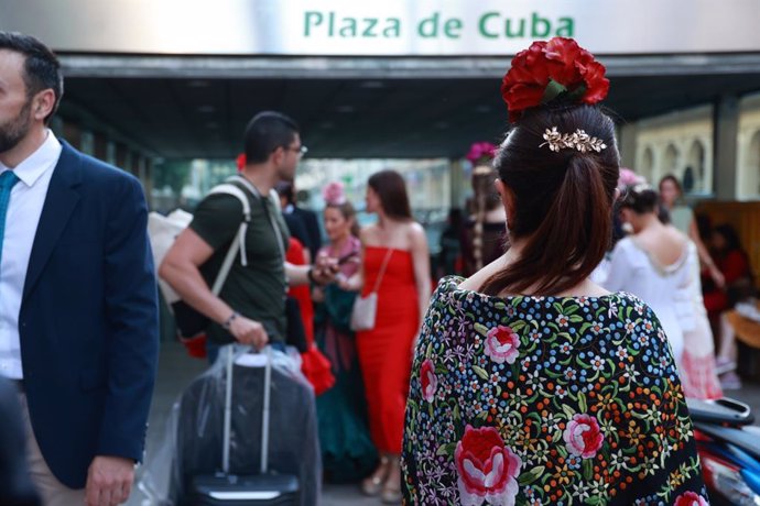 Viajeros ante la estación de metro de Plaza de Cuba durante la Feria de Abril