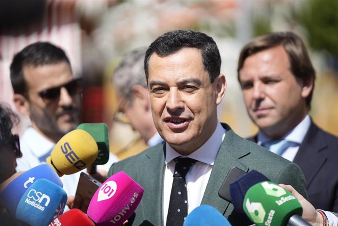 El presidente de la Junta de Andalucía, Juanma Moreno, atiende a los medios en la Feria de Sevilla.
