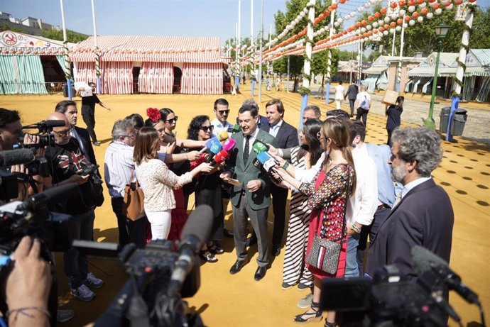 El presidente de la Junta de Andalucía, Juanma Moreno, durante una atención a medios en la Feria de Abril de Sevilla.