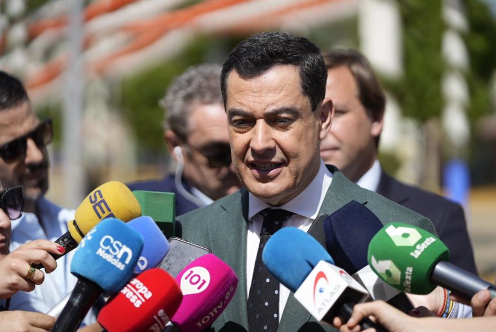 El presidente de la Junta de Andalucía, Juanma Moreno, atiende a los medios en la Feria de Sevilla.