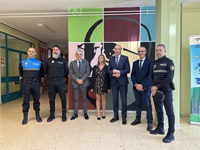 Foto de familia de las autoridades políticas, policiales y representantes del centro, en el acto de entrega del reconocimiento al grupo Paidos de la Policía Local de León.