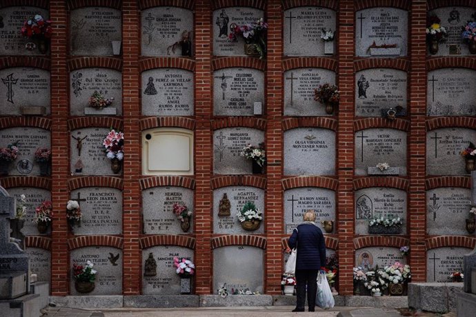 Archivo - Una mujer delante de varios nichos en el cementerio de la Almudena, a 1 de noviembre de 2023, en Madrid (España).