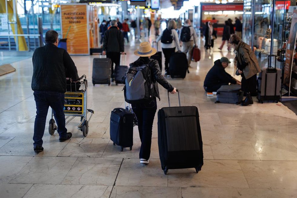 Archivo - Varias personas con maletas en la terminal T4 del aeropuerto de Adolfo Suárez-Madrid Barajas.