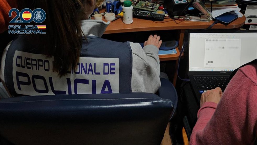 Agente de la Policía Nacional rastreando archivos informáticos.
