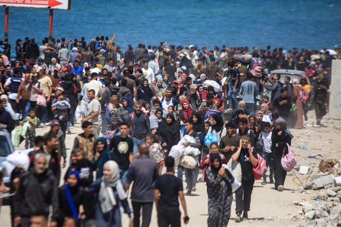 14 April 2024, Palestinian Territories, Nuseirat: Displaced Palestinians take the Rashid coastal road as they attempt to return to Gaza City as they pass through Nuseirat in the central Gaza Strip. The Israeli army stationed at the barrier separating sout