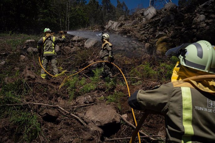 Axentes dos equipos de bombeiros traballan no lugar do incendio, a 16 de abril de 2024, en Crecentes, Pontevedra, Galicia (España). O incendio forestal foi declarado na tarde de onte e permanece activo en Crecente (Pontevedra) superando xa as 50