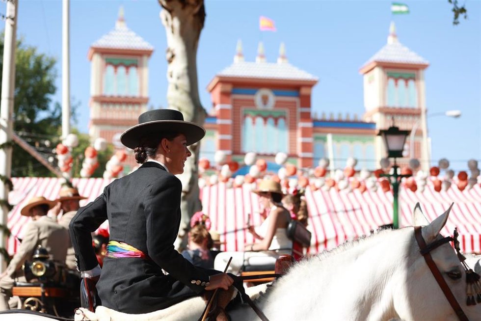 Una amazonas pasea a caballo junto a la portada.