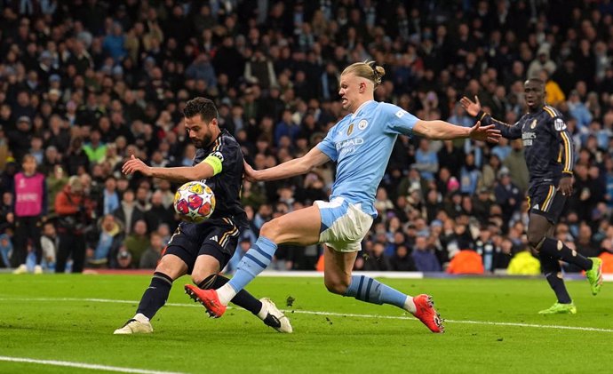 17 April 2024, United Kingdom, Manchester: Manchester City's Erling Haaland (C) and Real Madrid's Fernandez Nacho battle for the ball during the UEFA Champions League quarter-final second leg soccer match between Manchester City and Real Madrid at the Eti