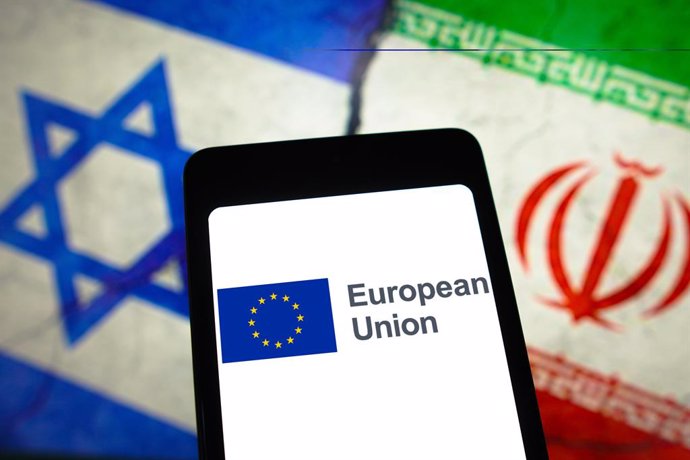 April 14, 2024, Brazil: In this photo illustration, the European Union (EU) logo is displayed on a smartphone screen and flags of Israel and Iran in the background.