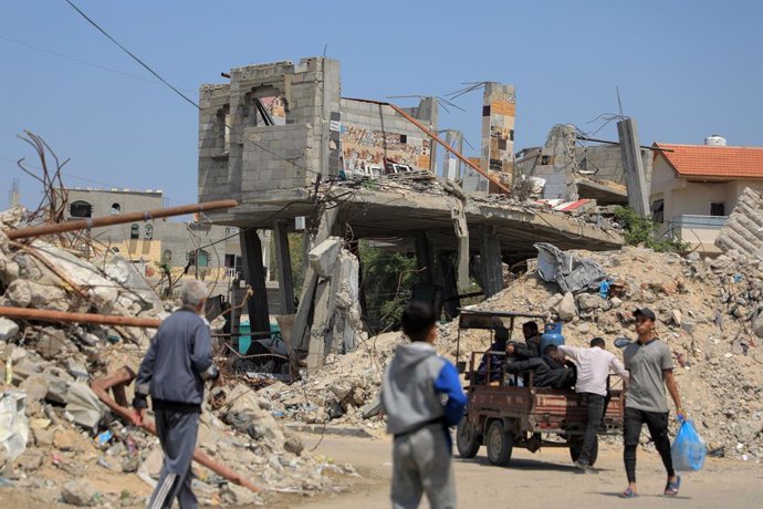 GAZA, April 16, 2024  -- People pass destroyed buildings in the southern Gaza Strip city of Khan Younis, on April 16, 2024. The Ministry of Health in Gaza announced Tuesday that the Palestinian death toll from ongoing Israeli attacks on the Gaza Strip has