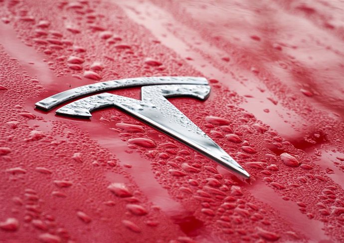 Archivo - FILED - 17 December 2021, Brandenburg, Bellitz: The logo on the wet hood of a red Tesla car. Photo: Soeren Stache/dpa-Zentralbild/dpa