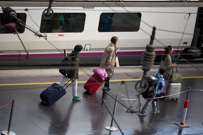 Varias personas esperan a un tren en un andén