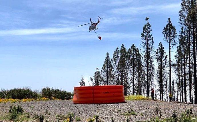 Un helicóptero prueba una balsa portátil de abastecimiento de agua durante un simulacro de incendio forestal