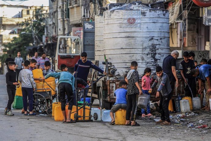 Un grupo de palestinos distribuye agua en la región de Rafá, en el sur de la Franja de Gaza