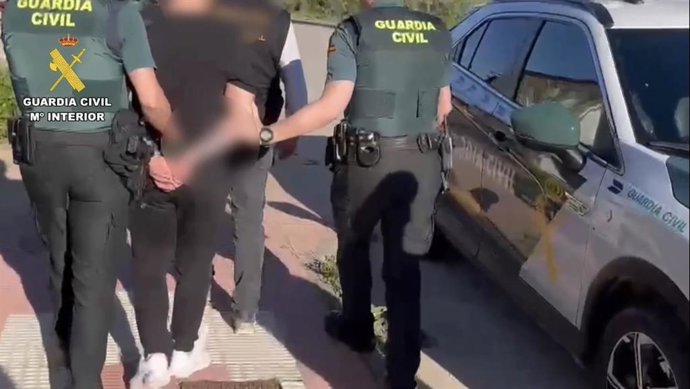 Agentes de la Guardia Civil custodian a dos de los detenidos.