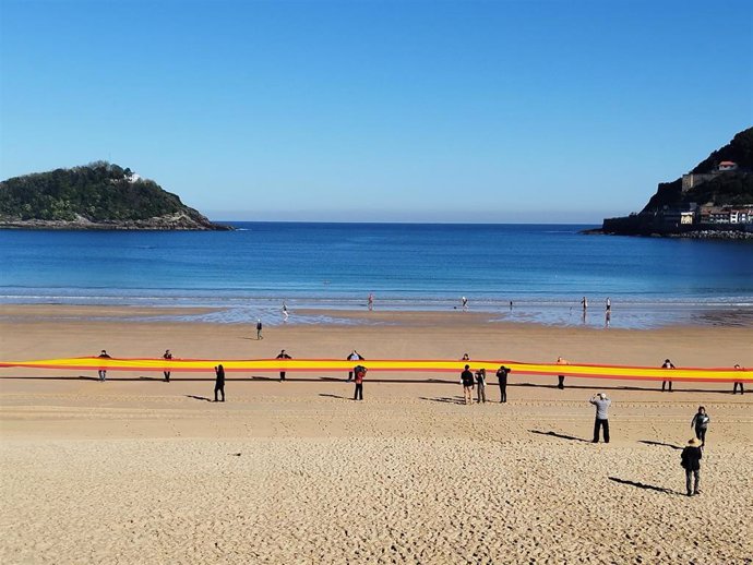 Vox despliega una bandera de 50 metros en la playa de La Concha de San Sebastián.