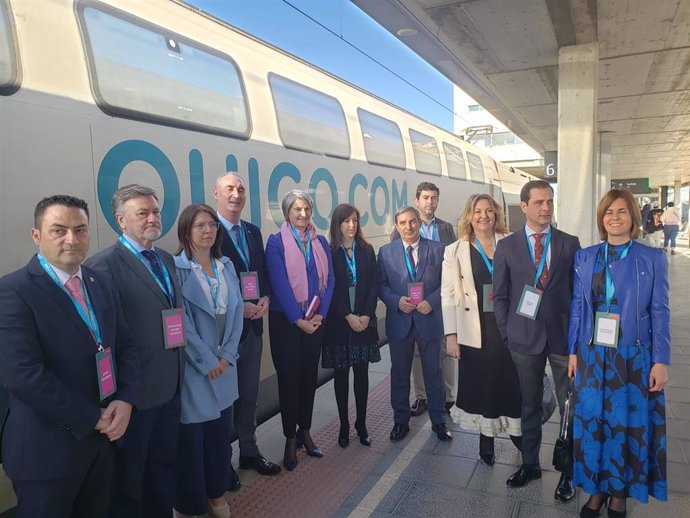 La directora general de Ouigo, Helene Valenzuela (centro, con foulard violeta) con las autoridades de Segovia, ante el tren que ha parado en su camino hacia Madrid.