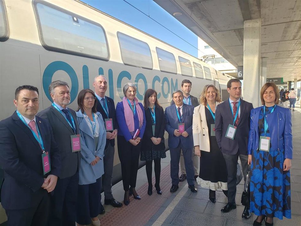 La directora general de Ouigo, Helene Valenzuela (centro, con foulard violeta) con las autoridades de Segovia, ante el tren que ha parado en su camino hacia Madrid.