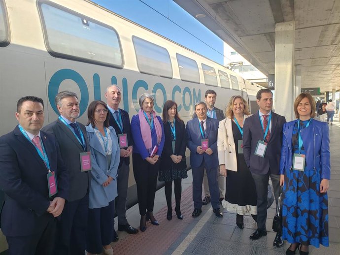 La directora general de Ouigo, Helene Valenzuela (centro, con foulard violeta) con las autoridades de Segovia, ante el tren que ha parado en su camino hacia Madrid.