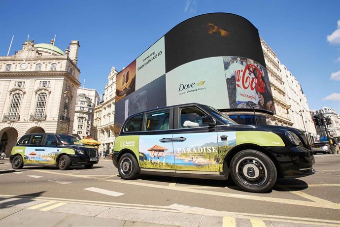 Taxi circulando por Londres con la imagen turística de Asturias.