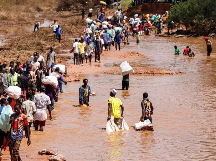 Archivo - BEIJING, Dec. 4, 2023  -- People wade through a flood-destroyed section at the Bangali-Garissa Road in Tana River County, Kenya on Dec. 1, 2023.   In the Mororo area at the border of Garissa and Tana River counties, eastern Kenya, residents are 