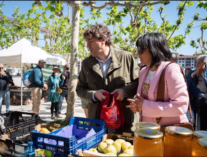 El candidato del PSE-EE a lehendakari, Eneko Andueza, con su mujer en el mercado de Portugalete.