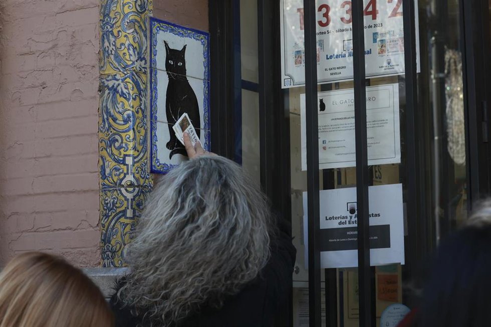 Archivo - Una persona frota un décimo de Lotería en Sevilla en imagen de archivo. 